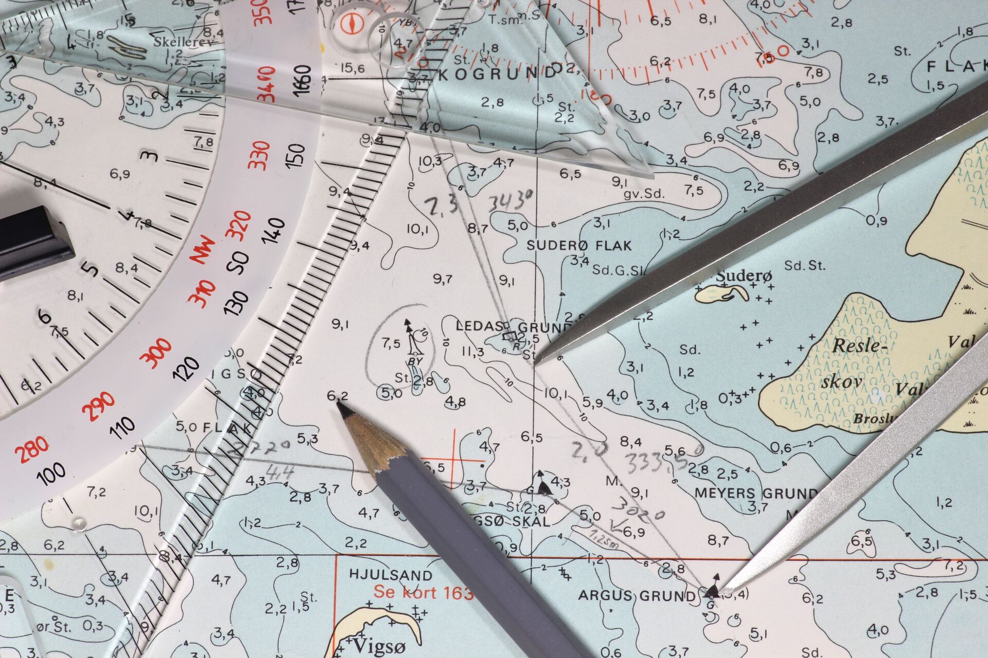 Navigation tools — compass, pencils, and dividers on a marine chart